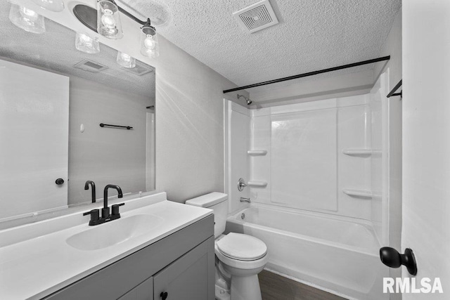 bathroom featuring vanity, toilet, a textured ceiling, and visible vents