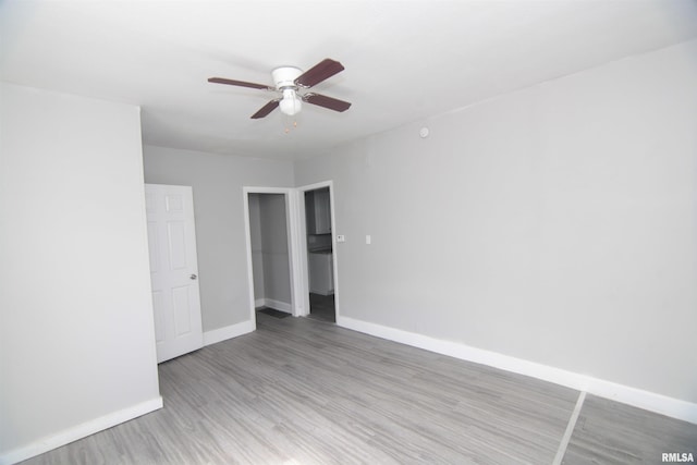 unfurnished bedroom featuring baseboards, a ceiling fan, and light wood-style flooring