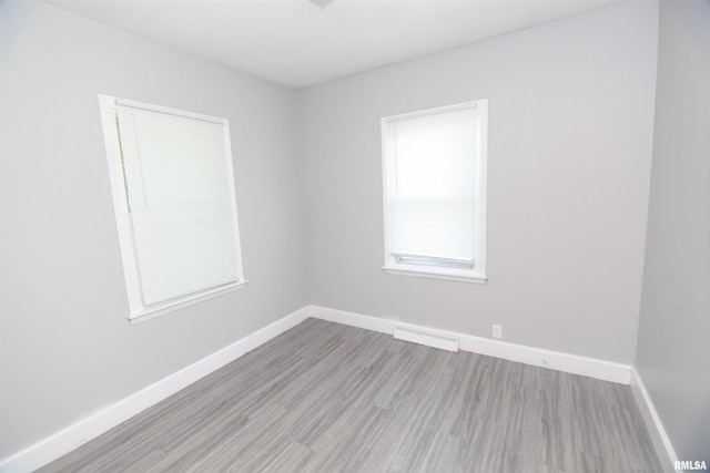 empty room with baseboards, wood finished floors, and visible vents