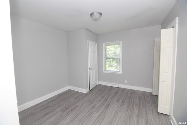 empty room with baseboards, wood finished floors, and visible vents