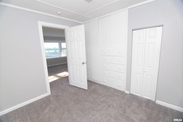 unfurnished bedroom featuring baseboards, carpet, and a closet