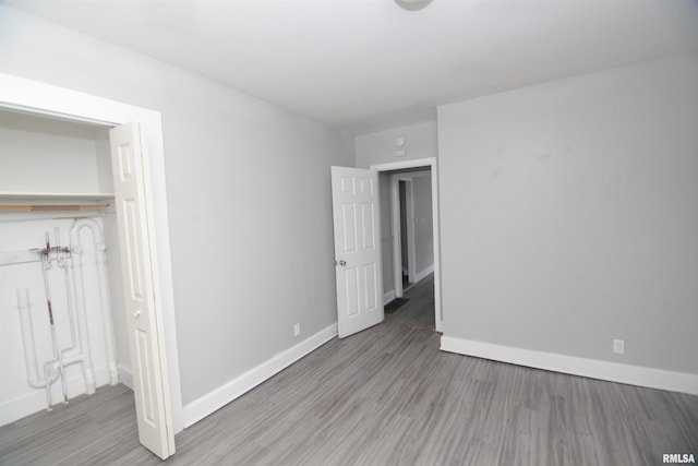 unfurnished bedroom with baseboards and wood finished floors