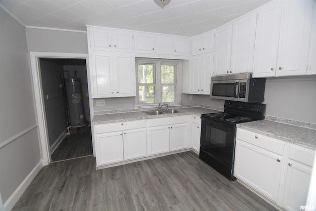kitchen with light countertops, stainless steel microwave, black range with electric stovetop, a sink, and water heater