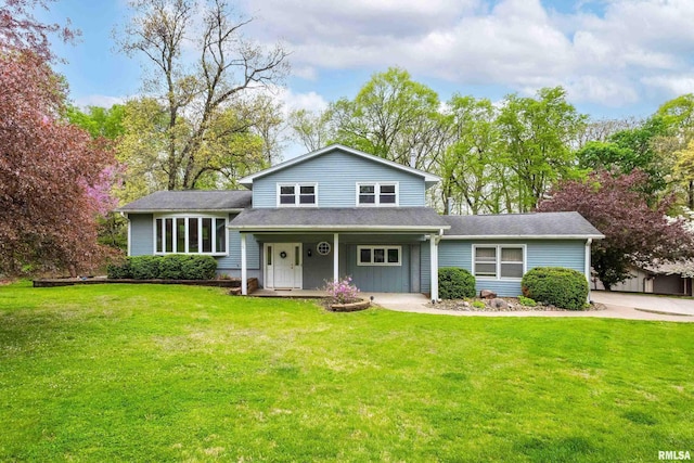 split level home featuring covered porch, roof with shingles, and a front lawn