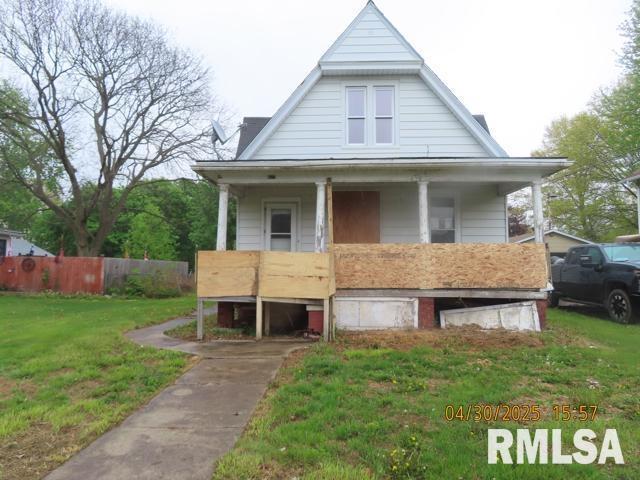bungalow featuring fence, a porch, and a front yard