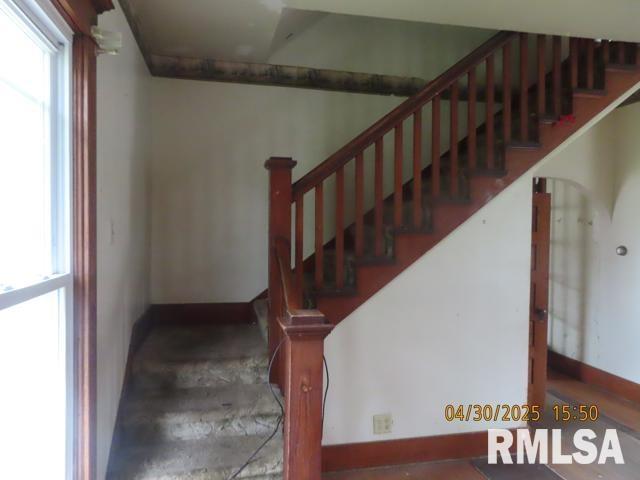 staircase featuring baseboards and a wealth of natural light