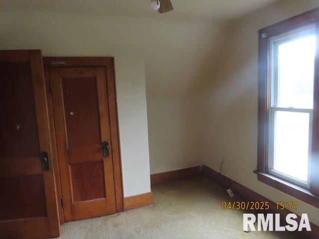 empty room featuring baseboards, ceiling fan, and light colored carpet