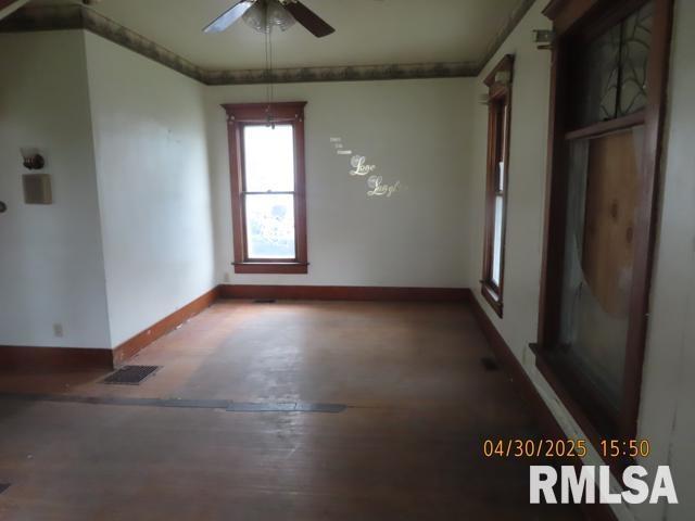 unfurnished room with baseboards, a ceiling fan, crown molding, and visible vents