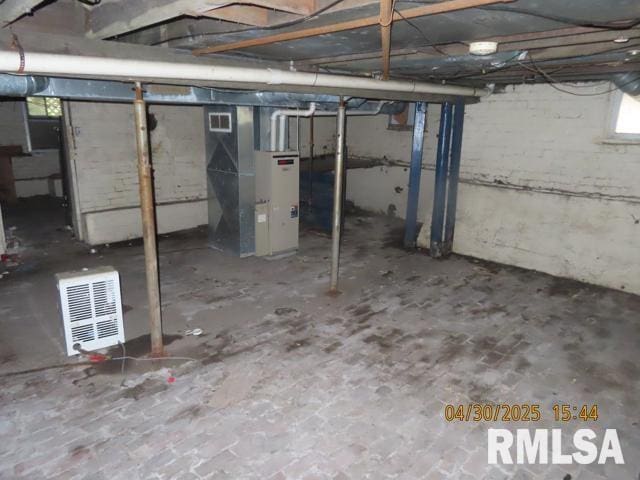unfinished below grade area with visible vents and heating unit