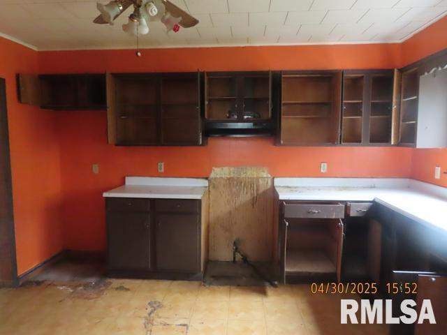 kitchen featuring exhaust hood, dark brown cabinetry, a ceiling fan, open shelves, and light countertops