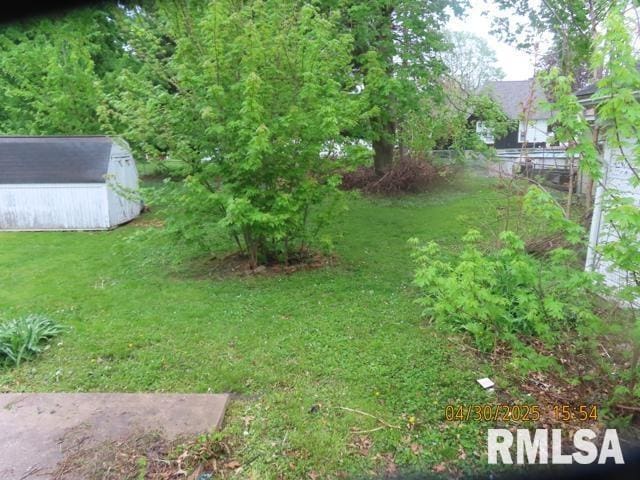 view of yard featuring a storage shed and an outbuilding