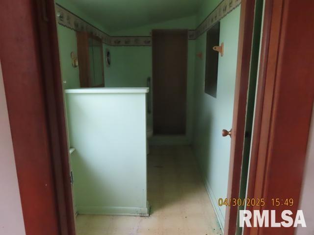 hallway with baseboards and light floors