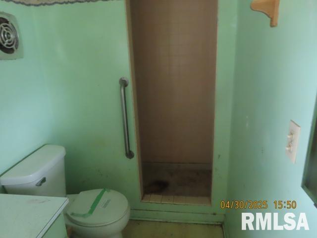 full bathroom with vanity, a shower, and toilet