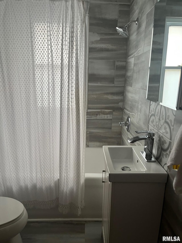 full bathroom with vanity, toilet, shower / bathtub combination with curtain, tile walls, and wood finished floors