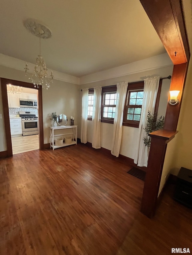 dining room featuring baseboards, visible vents, dark wood-style floors, and a chandelier