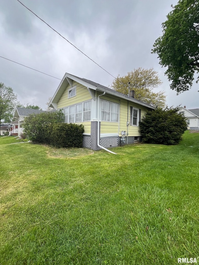view of side of home featuring a lawn