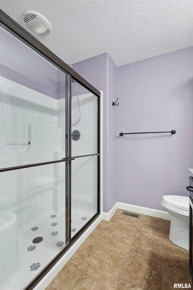 bathroom with toilet, baseboards, visible vents, and a stall shower