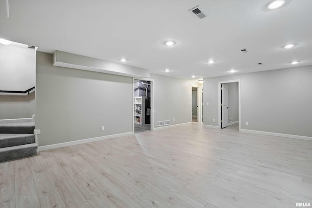 finished basement featuring stairs, recessed lighting, visible vents, and light wood-type flooring