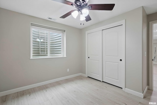 unfurnished bedroom featuring baseboards, visible vents, light wood-style floors, and a closet