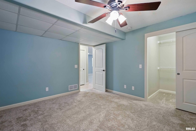 unfurnished bedroom with carpet, a ceiling fan, baseboards, visible vents, and a closet