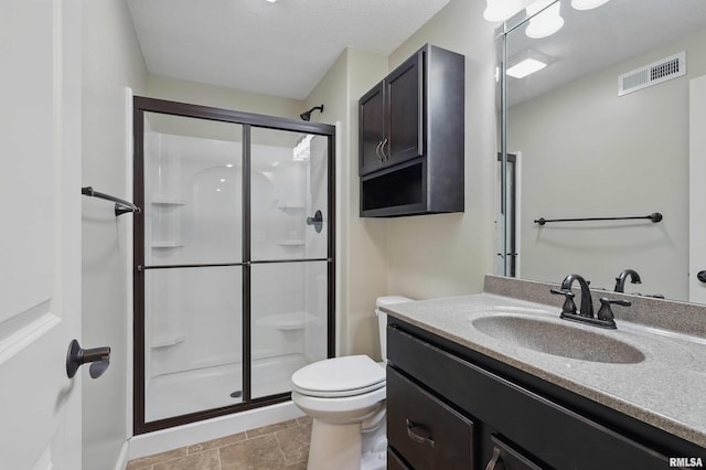 bathroom featuring vanity, toilet, visible vents, and a stall shower