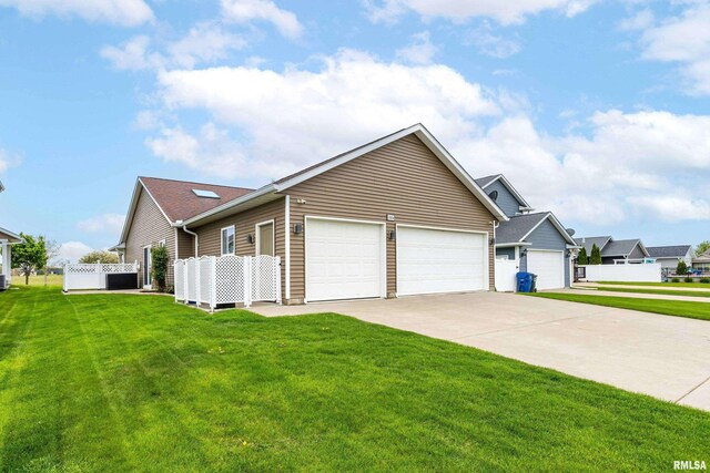 view of side of home featuring fence, an attached garage, concrete driveway, and a yard