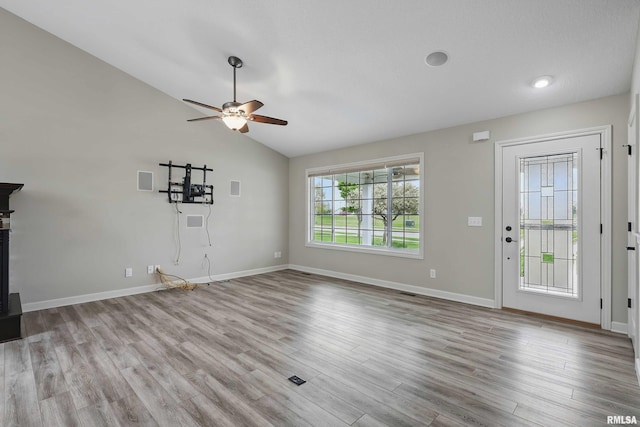 unfurnished living room with baseboards, a ceiling fan, wood finished floors, and vaulted ceiling