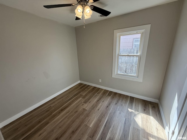 empty room with baseboards, ceiling fan, and wood finished floors