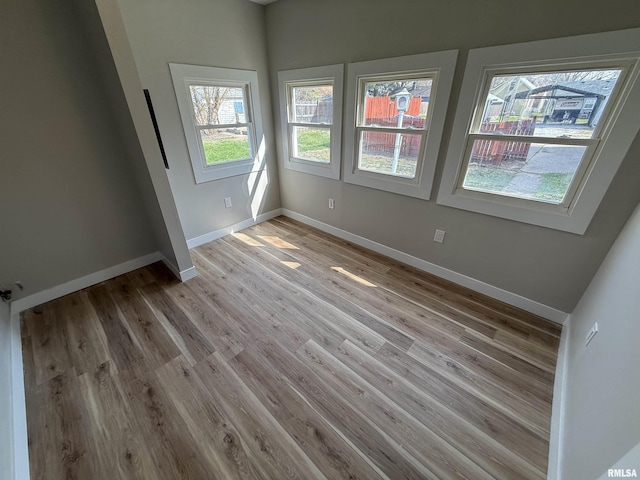 spare room featuring baseboards and light wood-style floors