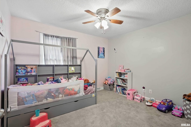 carpeted bedroom featuring a ceiling fan and a textured ceiling