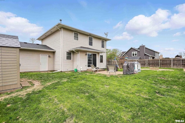 back of property with a lawn, a patio, and fence