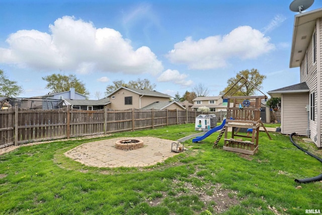 view of yard featuring a residential view, a patio area, a fenced backyard, a playground, and an outdoor fire pit