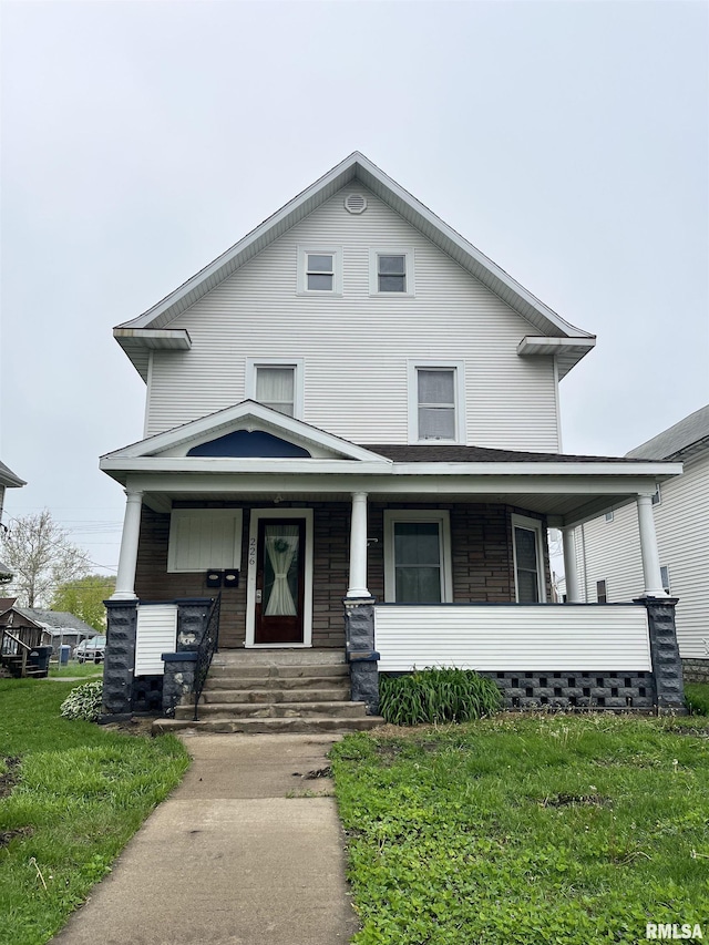 view of front of house with a porch and a front yard