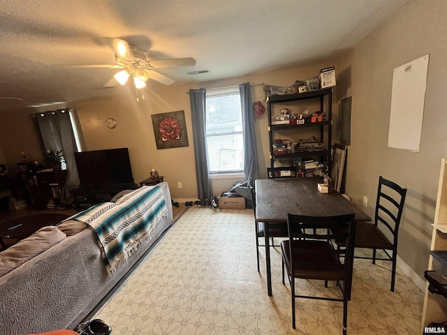 living area with visible vents, light floors, ceiling fan, and baseboards