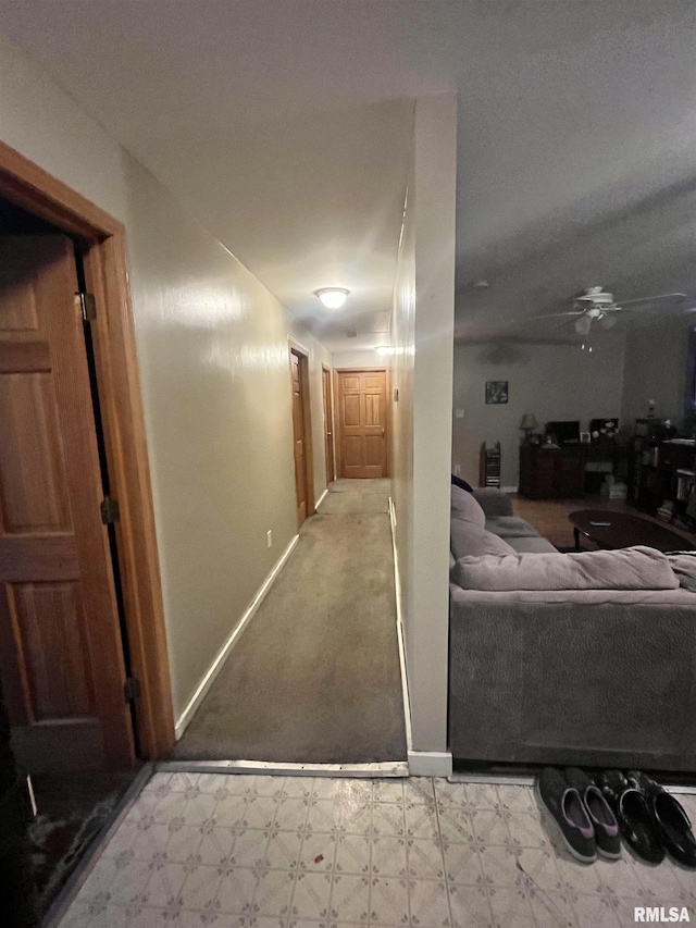 hall with tile patterned floors and baseboards