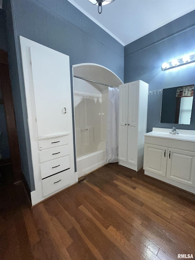 bathroom featuring crown molding, vanity, shower / bath combo with shower curtain, and wood finished floors