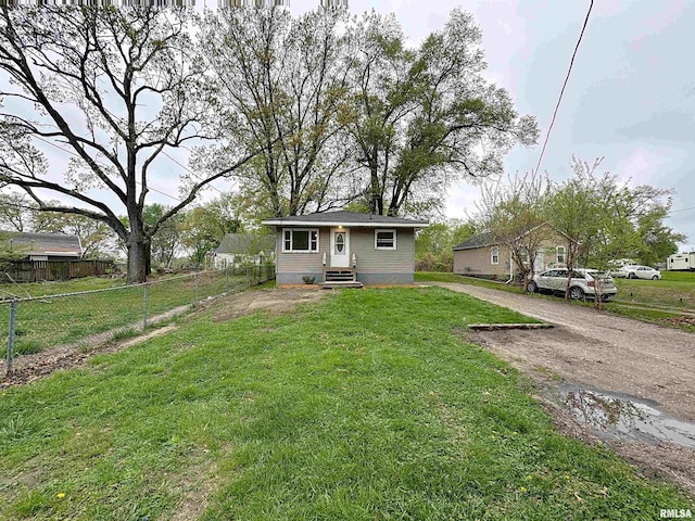 bungalow with dirt driveway, a front lawn, fence, and entry steps