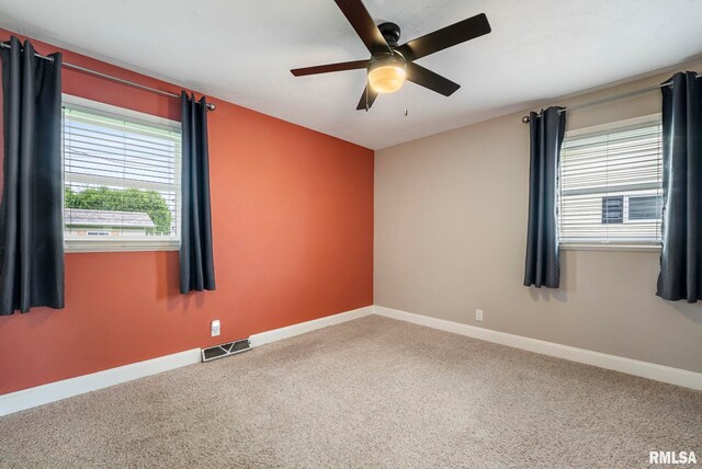 spare room with visible vents, a ceiling fan, baseboards, and carpet