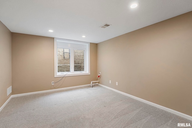 empty room featuring baseboards, light carpet, recessed lighting, and visible vents