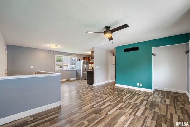 unfurnished living room with visible vents, baseboards, ceiling fan, and wood finished floors