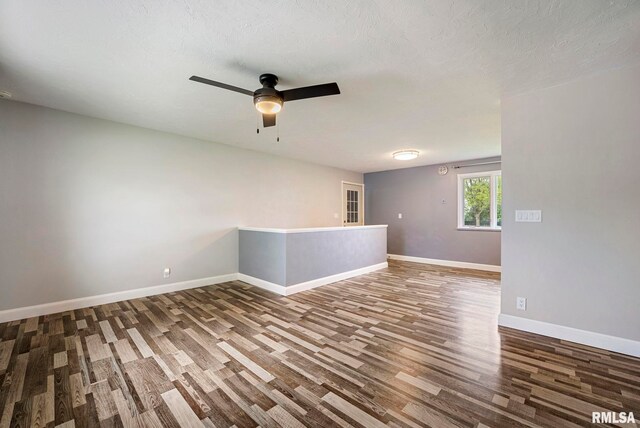 spare room with baseboards, ceiling fan, and wood finished floors