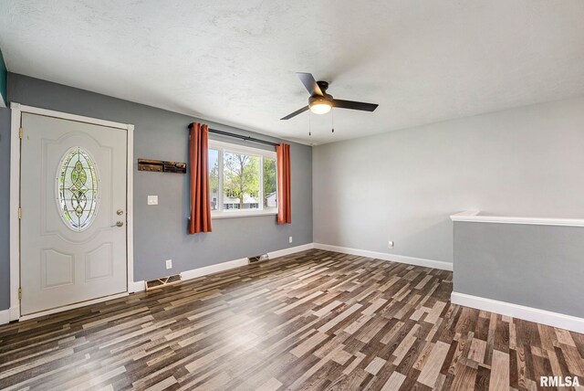foyer entrance with a ceiling fan, baseboards, visible vents, and wood finished floors