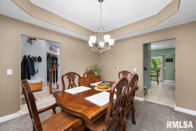 dining space with light carpet, baseboards, a tray ceiling, light tile patterned floors, and a notable chandelier