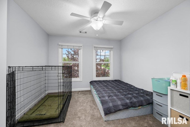carpeted bedroom with baseboards, ceiling fan, a textured ceiling, and visible vents