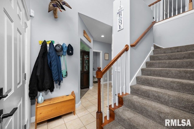 foyer entrance with baseboards, recessed lighting, tile patterned floors, and stairway
