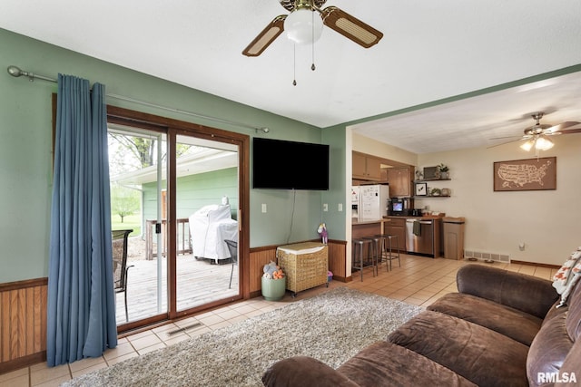 living room featuring visible vents, wainscoting, ceiling fan, and light tile patterned flooring
