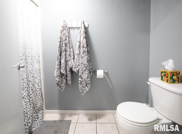 bathroom with baseboards, tile patterned flooring, toilet, and a shower with shower curtain