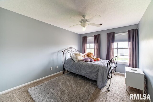 carpeted bedroom featuring baseboards, a ceiling fan, and a textured ceiling