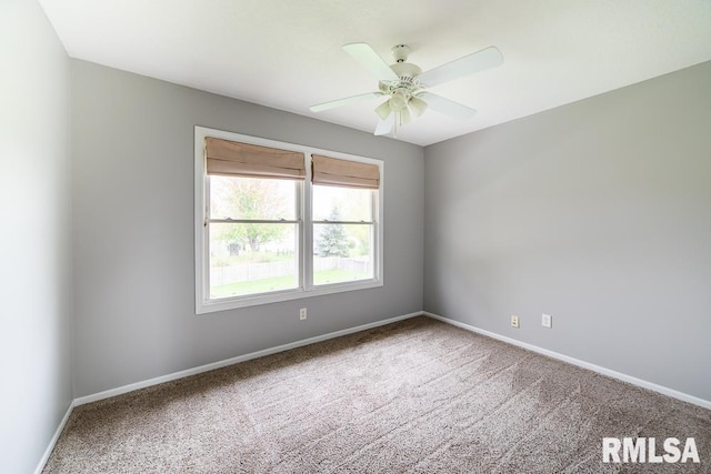 carpeted spare room featuring baseboards and ceiling fan