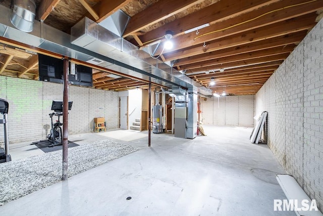 unfinished below grade area with stairs, heating unit, and gas water heater